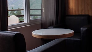 A hotel room with a large window, a round table, and two chairs. - Hotel Bhutan Home Thimphu (Thimphu)