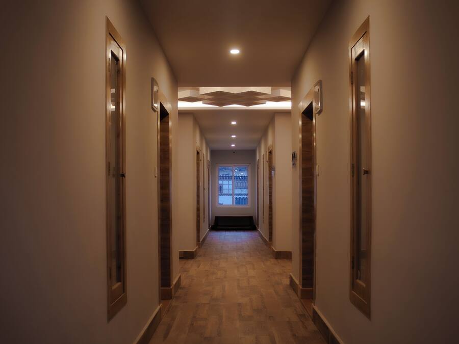 Un largo pasillo estrecho con suelo de madera e iluminación empotrada.