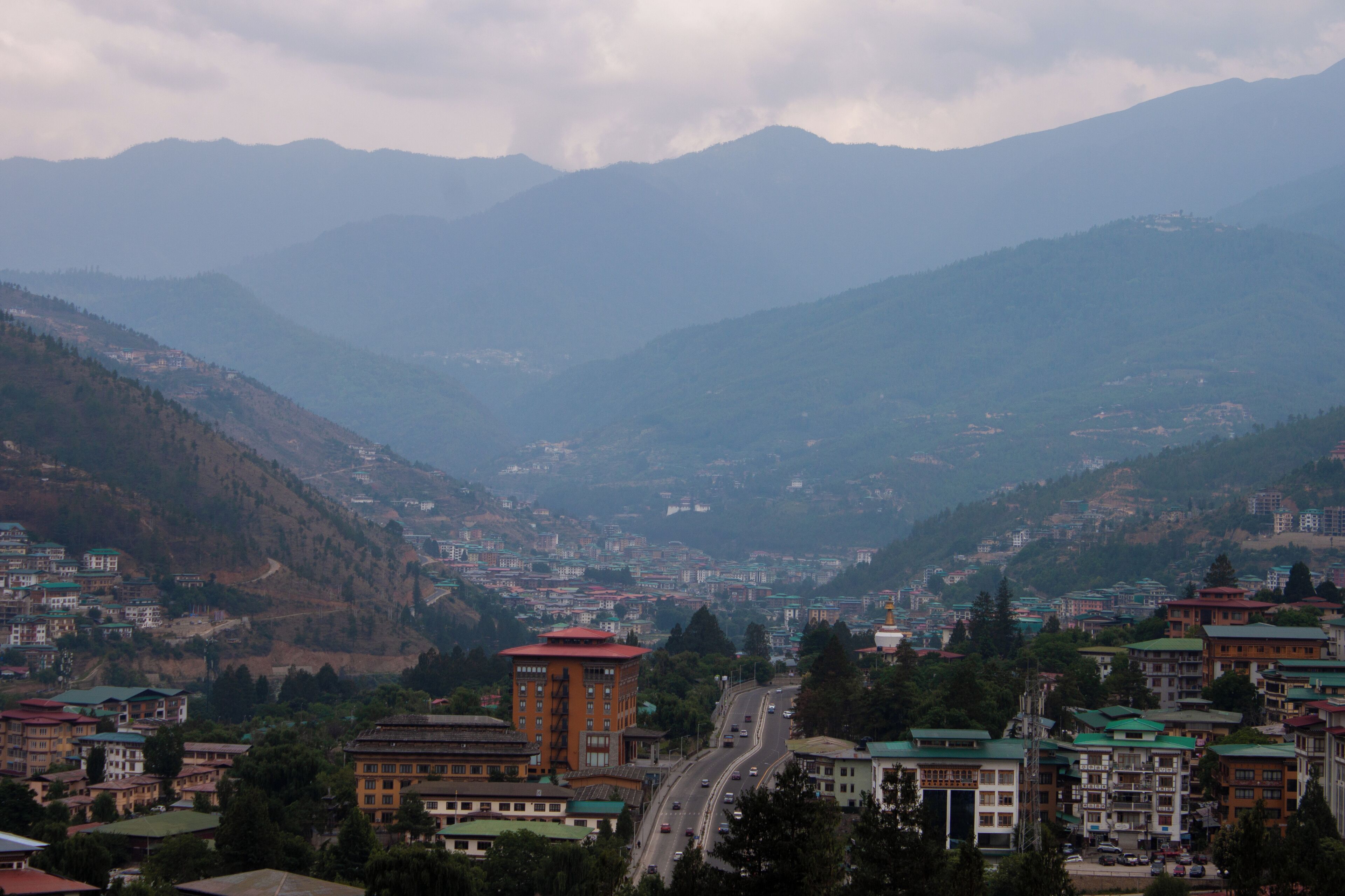 Uma cidade montanhosa com edifícios e estrada.