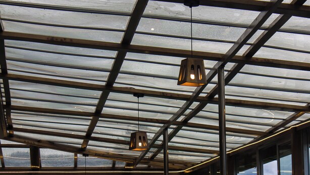 A restaurant with a glass roof, tables, and chairs. - Hotel Bhutan Home Thimphu (Thimphu)