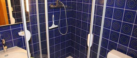 Une salle de bain avec une douche, des toilettes et un lavabo.