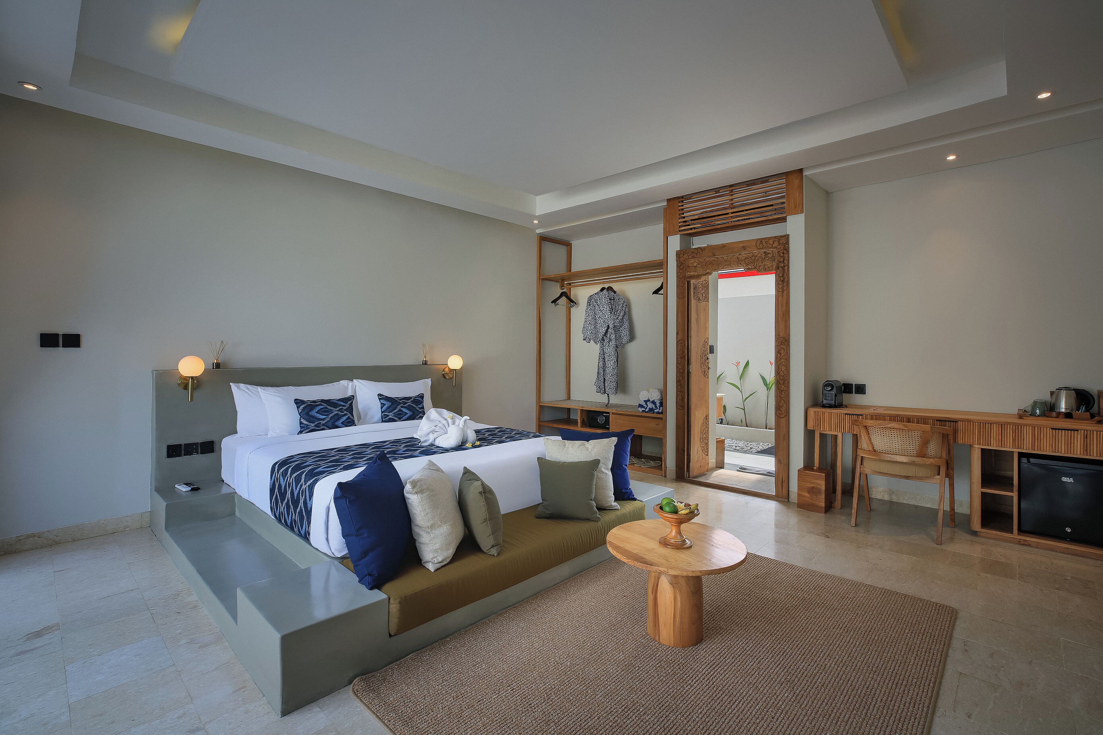 Un dormitorio moderno con una cama grande, mesitas de noche, un escritorio y una silla.