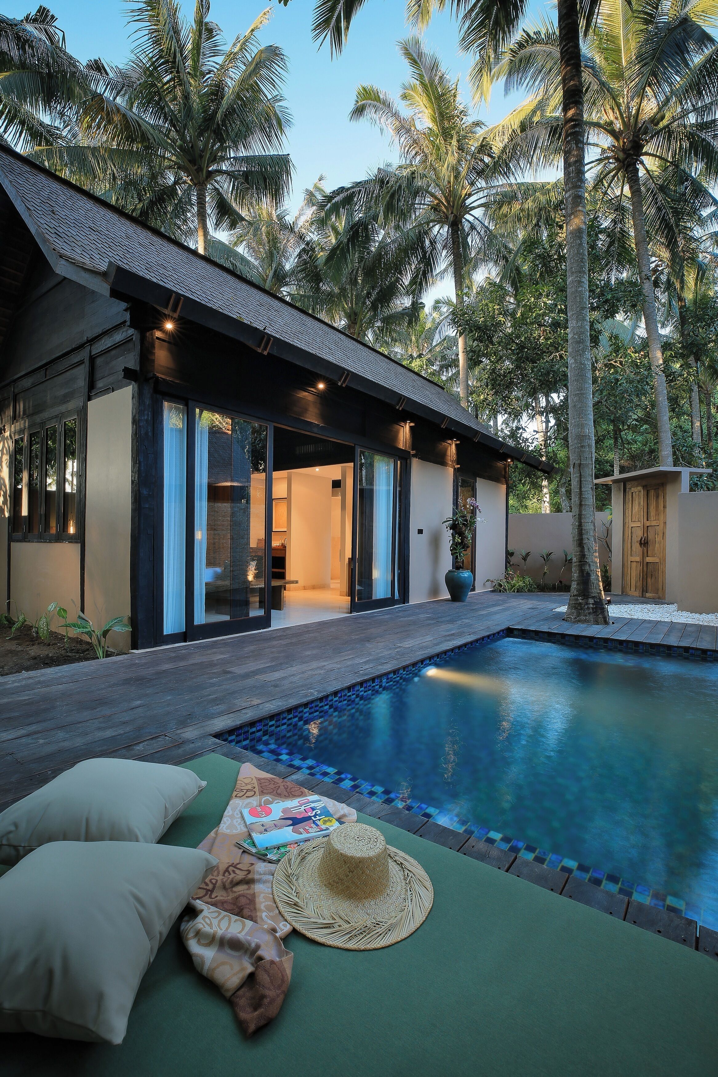 Ein modernes Haus mit Swimmingpool, umgeben von Palmen.