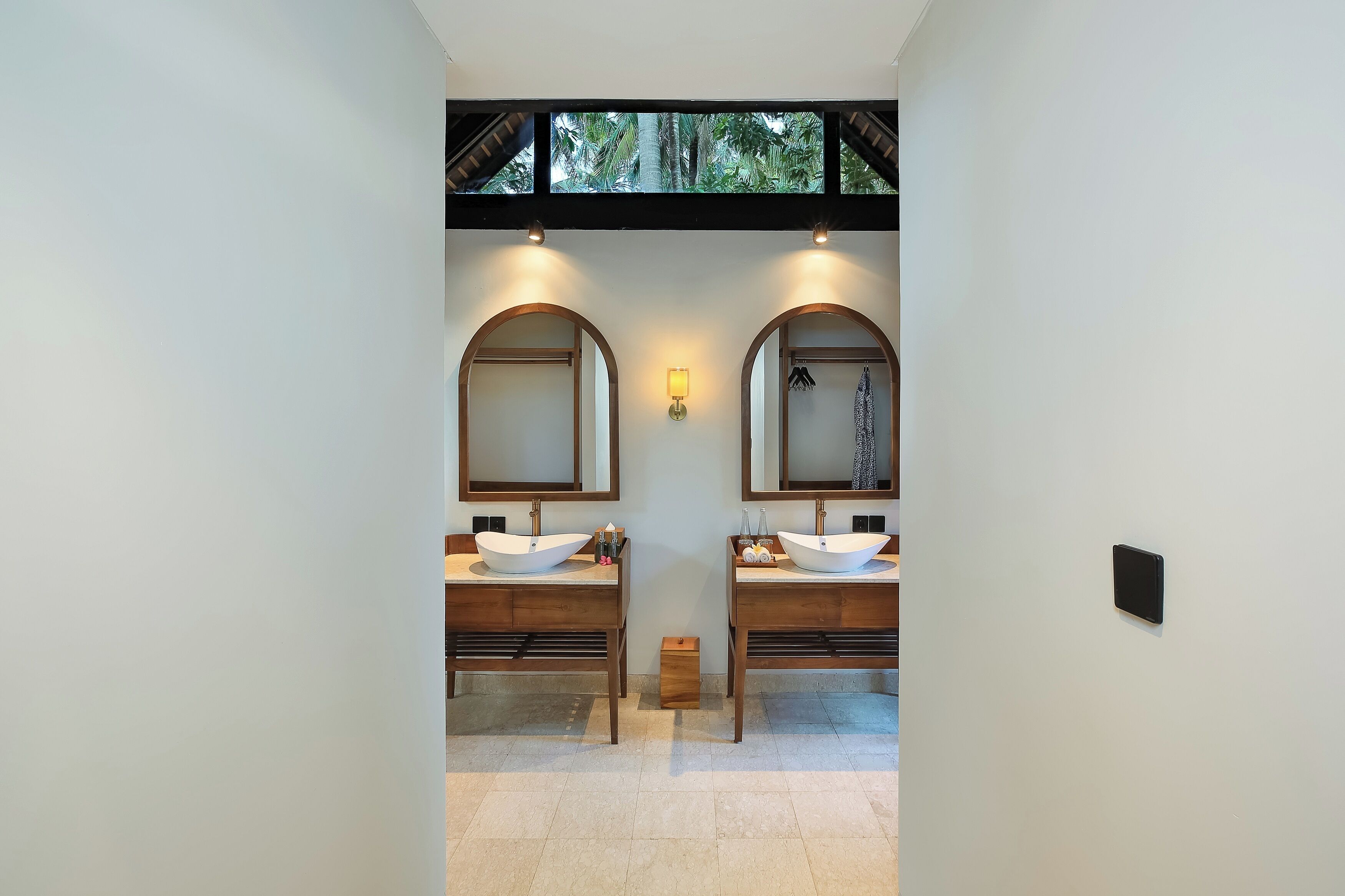 A modern bathroom with two sinks, each with a large mirror and a wall-mounted light.