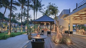 An outdoor patio area with a gazebo, seating, and palm trees. - The Sebali Penida Beach Resort (Penida Island)