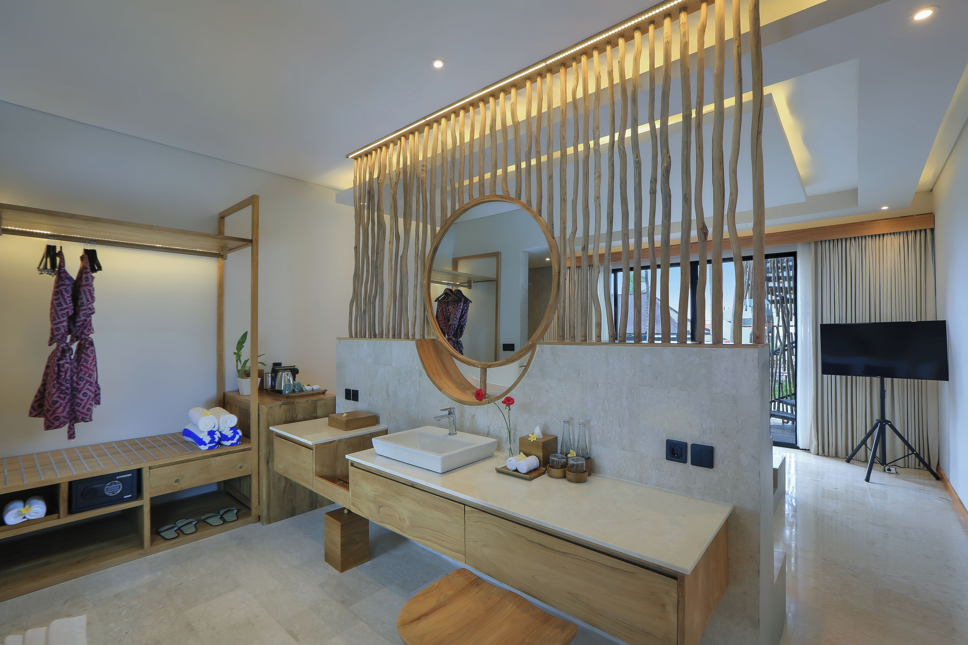 Une salle de bain moderne avec un meuble-lavabo en bois, un grand miroir et un banc.