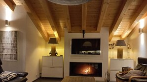 A cozy living room with a fireplace, wooden beams, and modern furniture. - Hilltop Apartment With Valley Views (Veysonnaz)