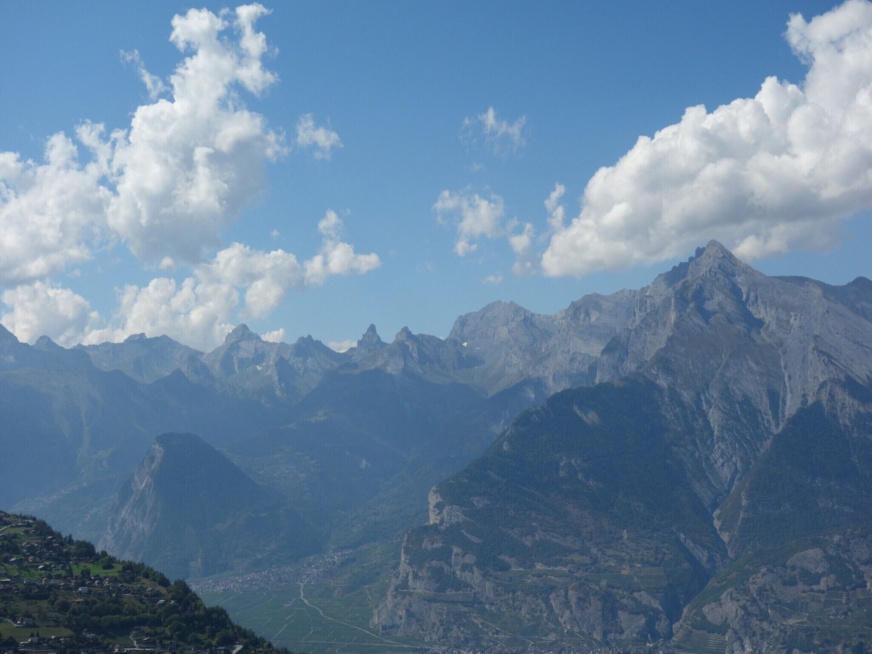 Eine Berglandschaft mit einem Tal und einer Stadt.