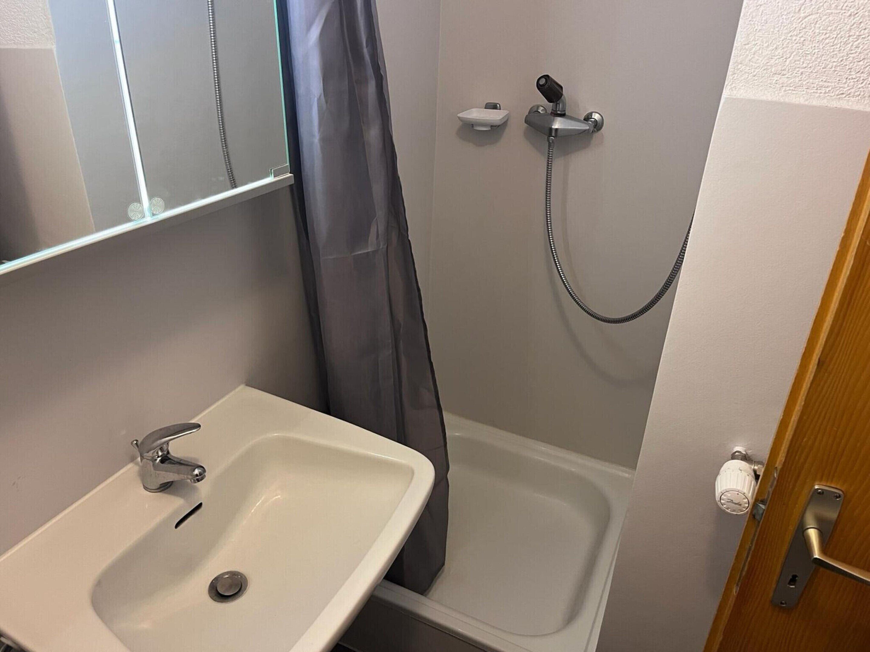 A bathroom with a sink, a shower, and a toilet.
