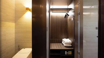A modern bathroom with a built-in shower, a towel rack, and a control panel.