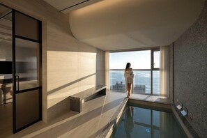 A modern interior with a pool, large windows, and a view of the sea. - Mer de laube Hotel (Busan)