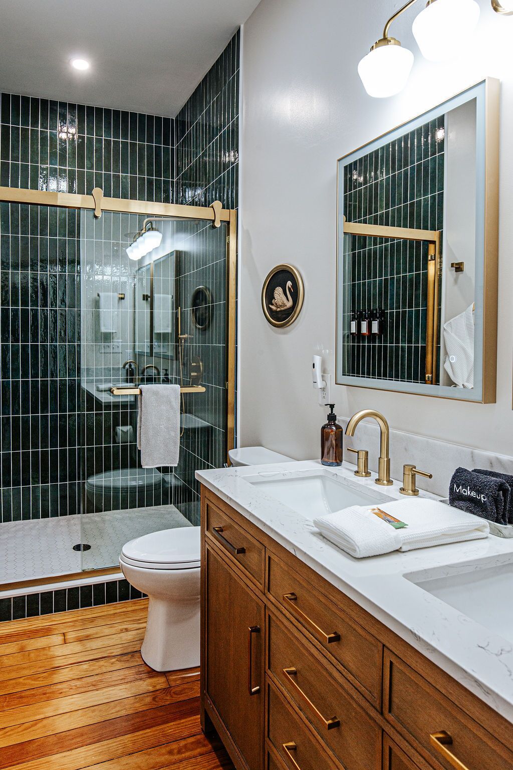 Une salle de bain moderne équipée d’une douche, de toilettes et d’un meuble-lavabo avec un miroir.