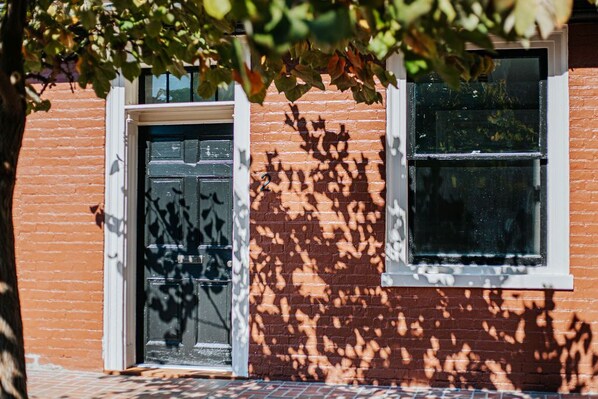 A brick building with a black door and a window. - Barristers Row (Staunton)