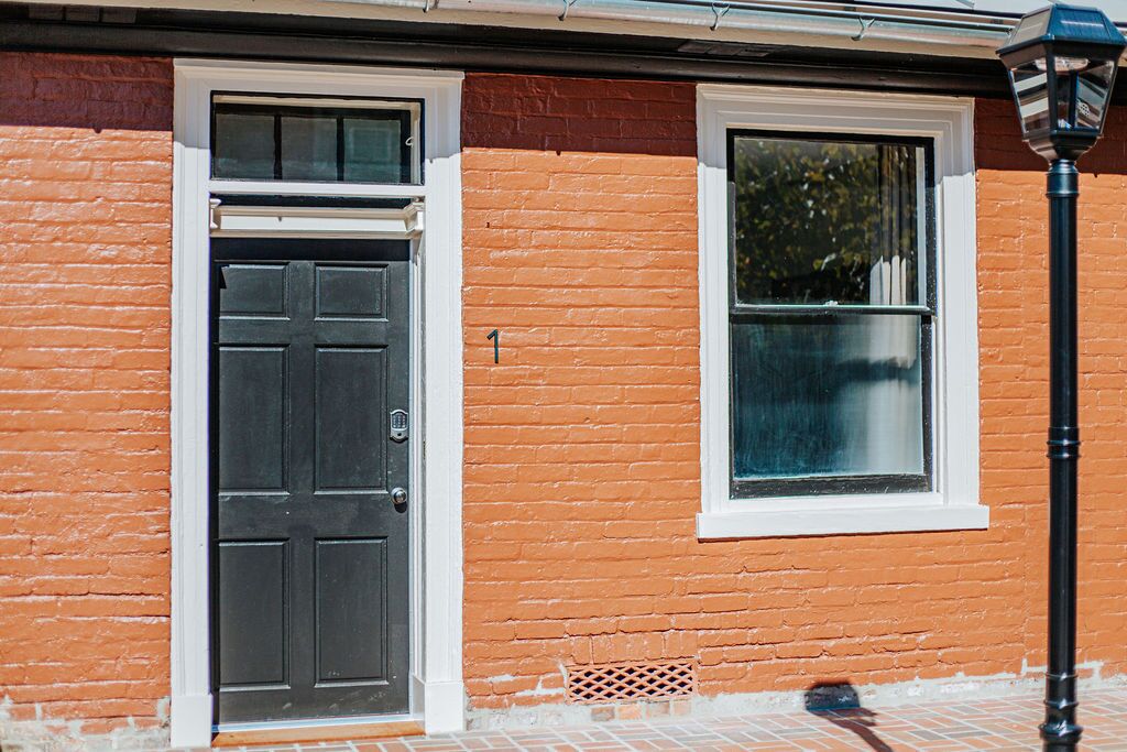 A building with a black door and a window with a white frame.