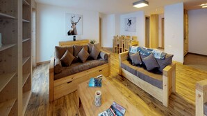 A modern living room with wooden furniture, a coffee table, and a bookshelf. - Luxury Apartment With View (Veysonnaz)