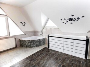 A modern bathroom with a freestanding bathtub, a large vanity with drawers, and a sloped ceiling with skylights. - Holiday Apartment in Nature (Frenstat pod Radhostem)