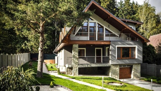 A modern two-story house with a stone facade, large windows, and a sloped roof. - Holiday Apartment in Nature (Frenstat pod Radhostem)