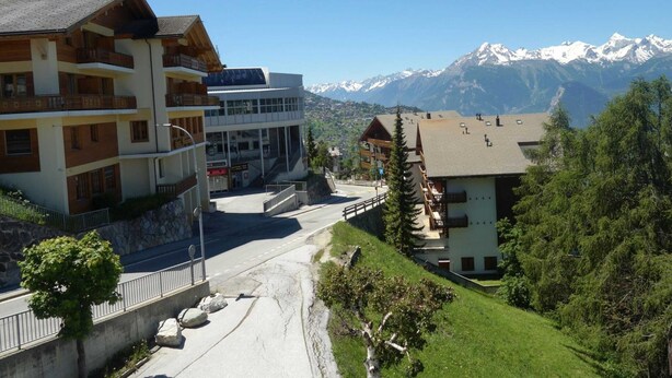 A hotel with a modern design, featuring balconies and a view of snow-capped mountains. - Apartment With Breathtaking Hill View (Veysonnaz)