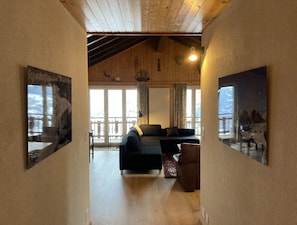 A wooden interior with a sofa, a lamp, and a painting on the wall. - Peaceful Apartment With Amenities (Veysonnaz)