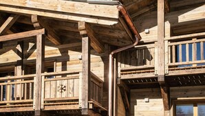 A wooden building with a balcony and a visible snowflake symbol.