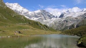 A mountain lake with clear water reflecting the surrounding peaks.