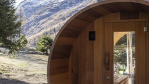 A wooden cabin with a curved exterior, a door, and a small window.