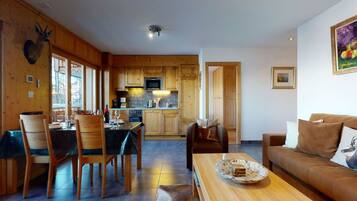 A cozy cabin interior with a dining area, kitchen, and living room.