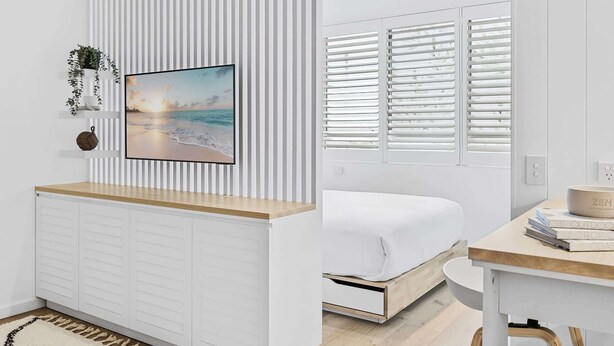 A modern bedroom with a bed, a desk, and a large window with blinds. - Studio4: Bondi Chic Interiors with Rooftop Pool (Bondi Junction)