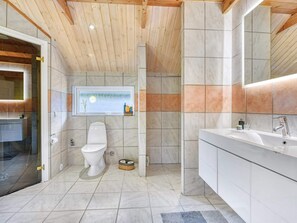 A modern bathroom with a toilet, sink, and shower area.