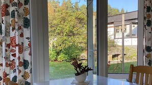 A dining area with a table, chairs, and a view of a garden through large windows. - 4 Person Holiday Home in Askloster (Åskloster)