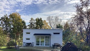 A modern, single-story cabin with a covered patio, surrounded by a natural landscape. - 4 Person Holiday Home in Askloster (Åskloster)