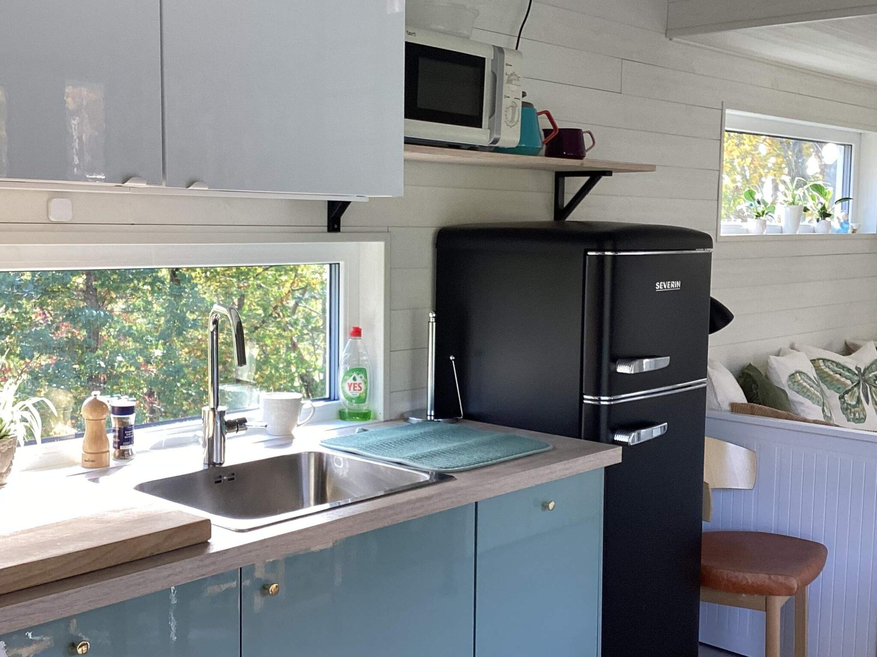 A compact kitchen with a sink, a microwave, and a refrigerator.