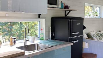 A compact kitchen with a sink, a microwave, and a refrigerator.
