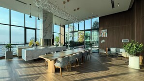 A modern kitchen with a marble island, large windows, and a view of the city. - D'Edge Thao Dien (Ho Chi Minh City)