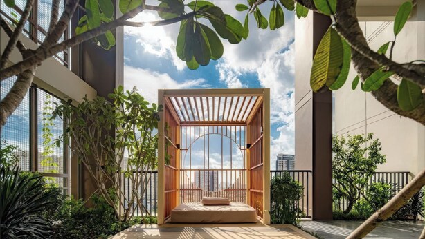 A modern outdoor seating area with a wooden structure and a view of the city skyline. - D'Edge Thao Dien (Ho Chi Minh City)
