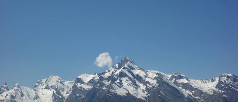 Une chaîne de montagnes dont les sommets enneigés se dressent sous un ciel bleu dégagé.