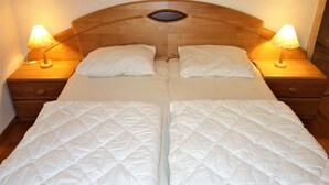 A double bed with a wooden headboard and two bedside tables with lamps. - Nice Apartment Near Ski-lift (Veysonnaz)