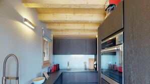 Een moderne keuken met donkere kastjes, een roestvrijstalen spoelbak en een ingebouwde oven.