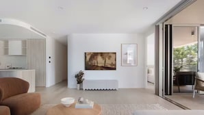 Ein modernes Wohnzimmer mit einer Couch, einem Couchtisch und Kunstwerken an der Wand.