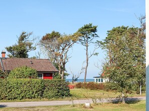 A coastal property with a red house, a white building, and a view of the sea. - 6 Person Holiday Home in Skummeslovsstrand (Skummesloevsstrand)