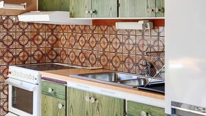 A kitchen with green cabinets, a stainless steel sink, and a white stove. - 6 Person Holiday Home in Skummeslovsstrand (Skummesloevsstrand)