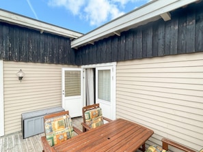 A patio with a wooden table and chairs, a radiator, and a door leading to an interior space. - 6 Person Holiday Home in Skummeslovsstrand (Skummesloevsstrand)