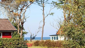 A coastal property with a red building, a white building, and a view of the sea. - 6 Person Holiday Home in Skummeslovsstrand (Skummesloevsstrand)