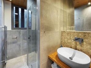 A modern bathroom with a glass shower enclosure, a large sink, and a stone-patterned backsplash. - Spacious Villa With Good Ambience (Cerny Dul)
