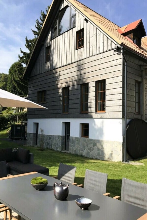 A two-story house with a stone foundation and a sloped roof. - Holiday Villa for Families (Tanvald)