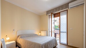 Ein Schlafzimmer mit Bett, Nachttisch, Stuhl und einem Fenster mit Ausblick.