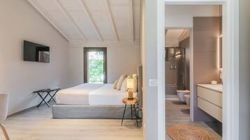 A modern bedroom with a large bed, bedside table, and a TV mounted on the wall.