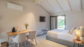 A modern bedroom with a bed, bedside table, lamp, and a desk with chairs.