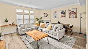 A living room with a sofa, coffee table, and dining area.