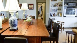 A wooden dining table with chairs, surrounded by blue and white patterned vases and a basket with flowers. - Stylish Atlanta Retreat! (Atlanta)